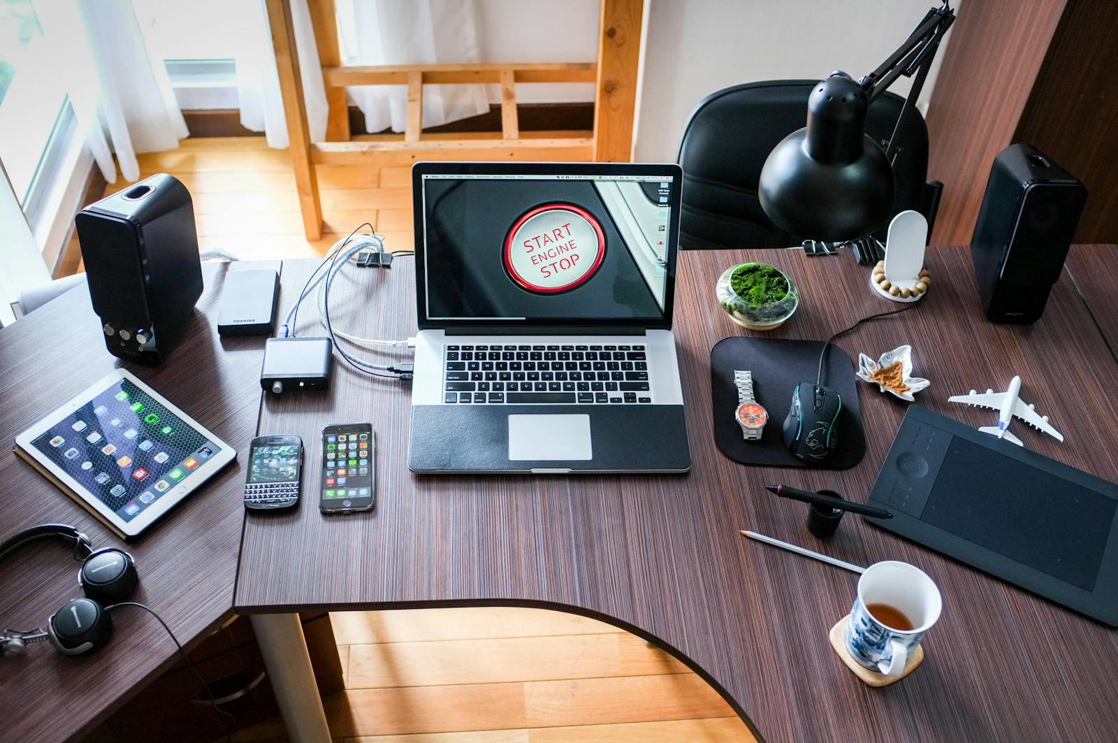 A contemporary office desk setup with laptops, gadgets, and accessories, creating a tech-savvy workplace, business